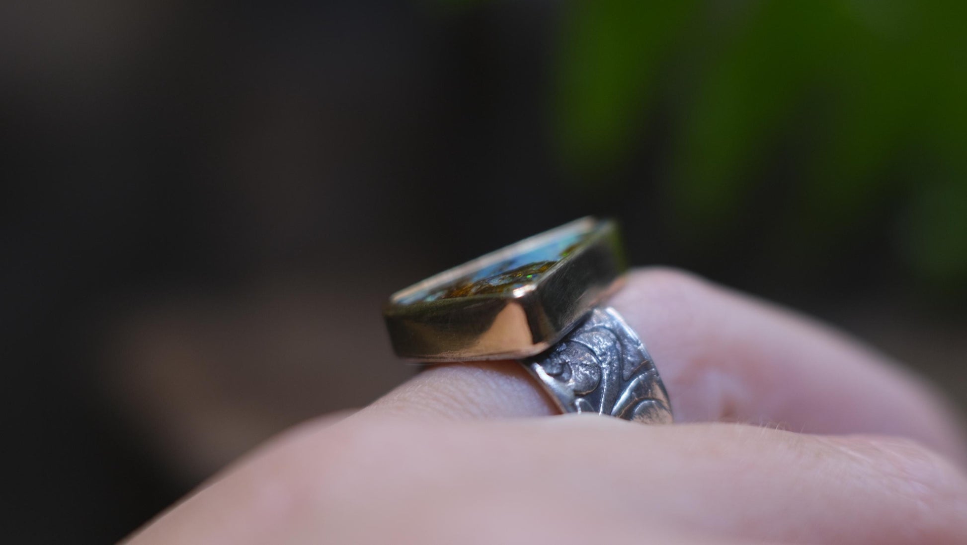 Striking electric blue opalised fossil wood set in 9ct Gold on piratey textured silver band